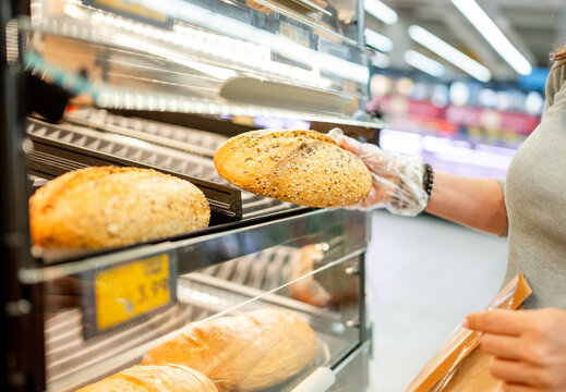 Customer selecting fresh bread loaf at local grocery store