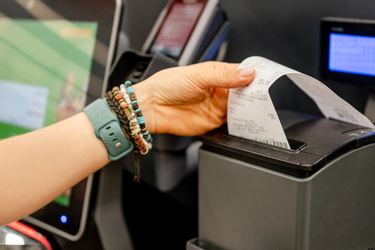 Customer taking printed receipt from self service machine