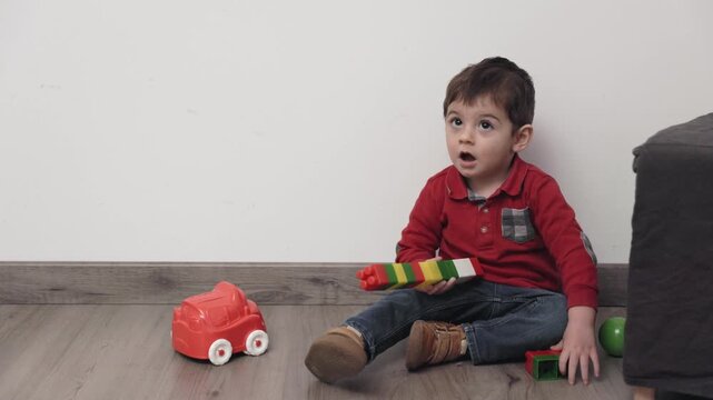 Toddler playing with colorful blocks and car toy