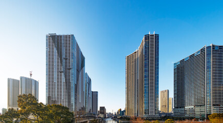 Fototapeta premium 青空に向かってそびえ立つ高層タワーマンションと街並み