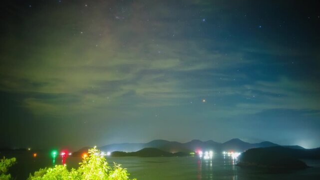Dynamic Night Sky Timelapse with Star Trail Overlay Over South Coast Sea and Drifting Clouds