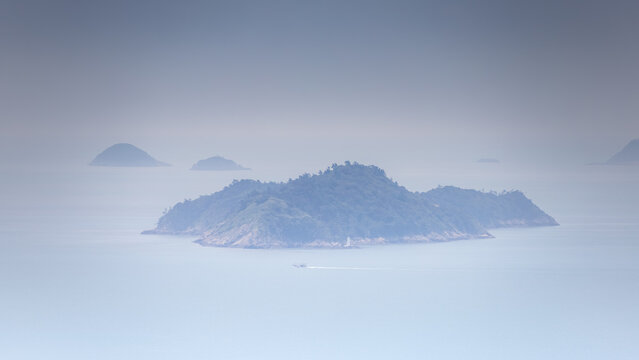 Minimalist Ink Wash Style Landscape of Misty Islands and Solitary Boat Sailing Across Hazy Calm Sea in Dadohaehaesang National Park, South Korea