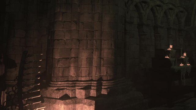 Light shines on stone structures in an old location. Shadows stretch across the ground, creating a sense of depth. The setting holds a quiet, intriguing atmosphere in the dim light.