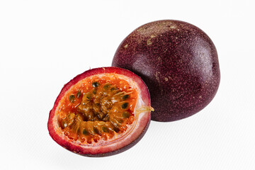 Halved passion fruit with vibrant orange pulp and black seeds on white background