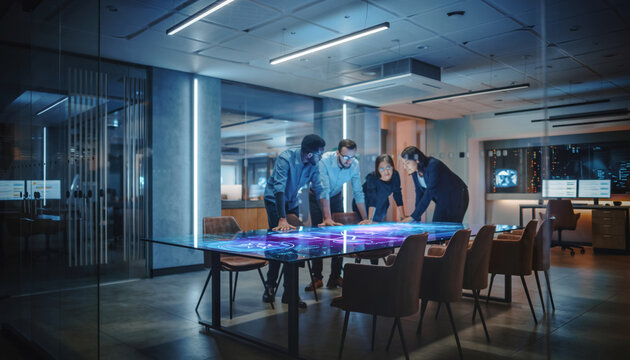 Diverse team analyzing data on futuristic digital touch table