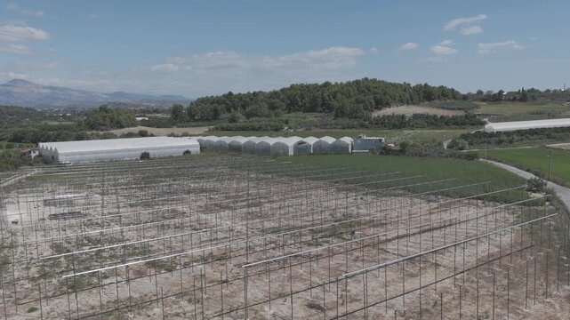 Aerial drone flight over the metal skeleton framework of a greenhouse under construction.  [D-Log M]