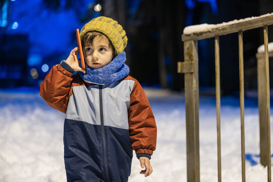 Child talking on smartphone in winter snow