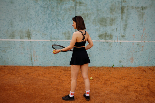 Young woman playing tennis on clay court