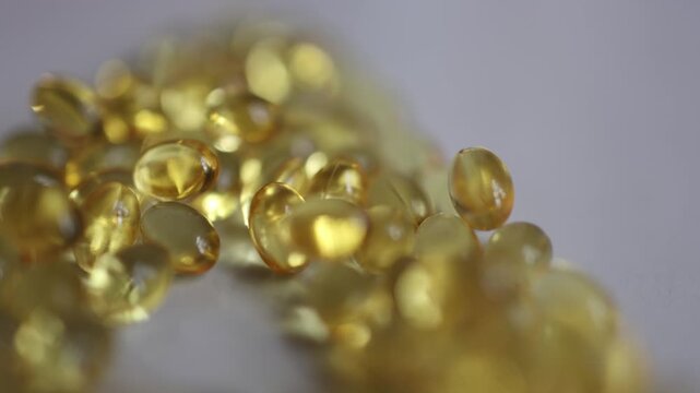Omega 3 softgel capsules in macro close up showing golden fish oil supplements for daily nutrition heart brain wellness healthy lifestyle and essential fatty acid intake