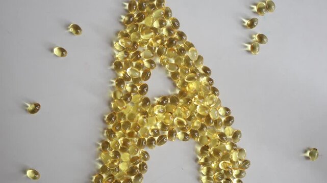 Vitamin A softgel capsules arranged as a large letter A on white background representing supplements essential nutrients wellness vision skin health and healthy lifestyle