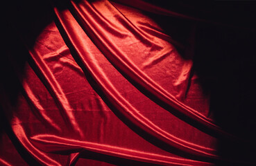 Fototapeta premium Red curtain stage illuminated by a spotlight in a dark theater