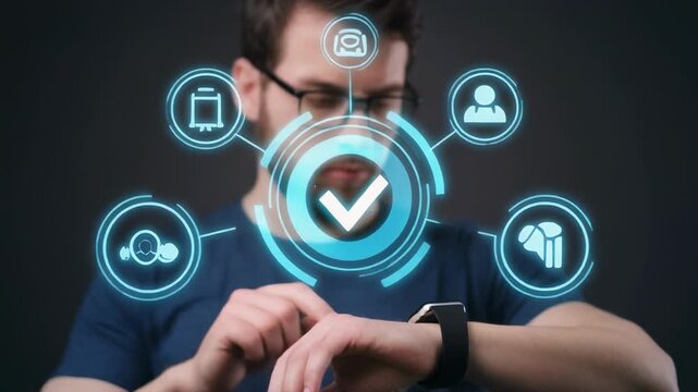 Man checking smartwatch showing digital interface with checkmarks and icons during dark studio lighting
