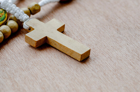 Side view of Holy Rosary on wooden table with customizable space for text. Religion concept.