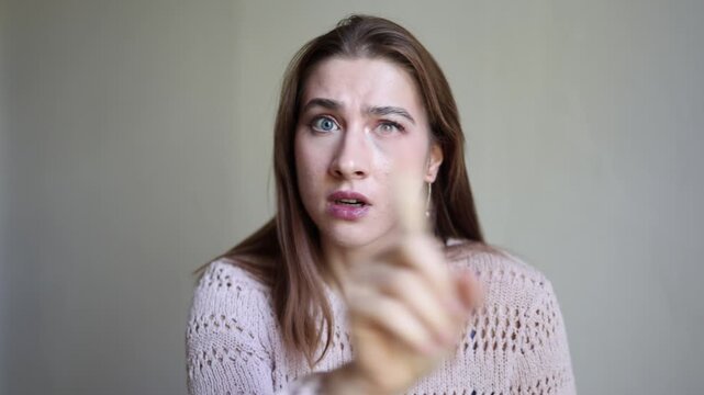 Young woman looks confused and frustrated while crossing her hands in refusal expressing disagreement rejection doubt concern and a strong negative response to camera now