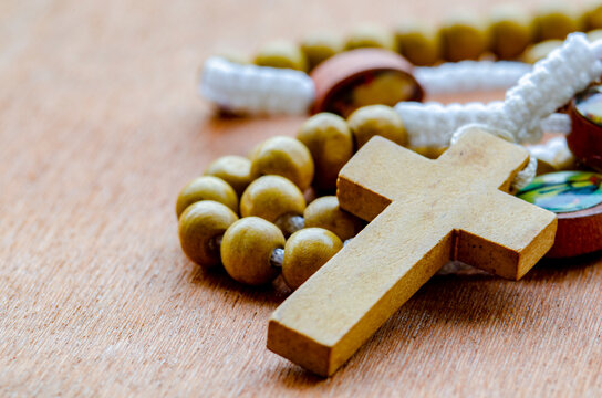 Close up view of Holy Rosary on wooden table. Religion concept.