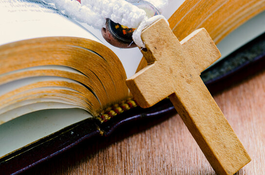 Close up view of wooden Holy Cross and Holy Bible with customizable space for text. Religion concept.