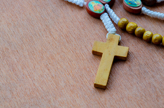 Top view of Holy Rosary on wooden table with customizable space for text. Religion concept.