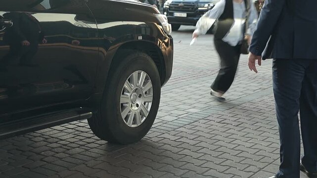 Bodyguard Standing Beside a Bulletproof SUV