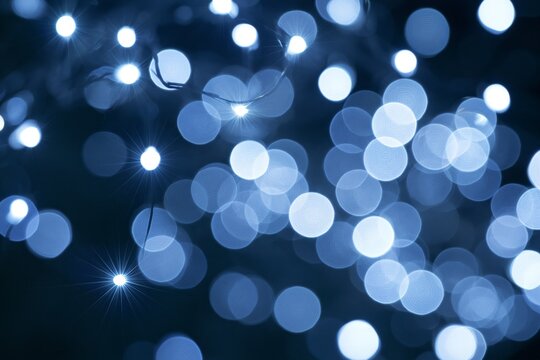 Close-up abstract of numerous cool white and icy blue decorative string lights suspended against deep charcoal background with sharp sparkling points and layered circular bokeh effects subtle silver