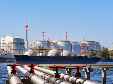 LNG terminal operations. Gas carrier unloads liquefied natural gas at a storage facility with pipelines, valves and large industrial tanks.