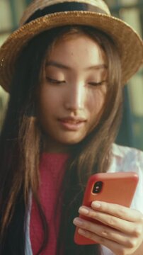 Travel enthusiast casually holding her smartphone outdoors while dressed casually and enjoying nature
