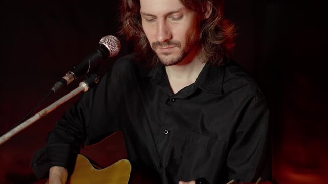 A guy in a black shirt is singing into the microphone.
