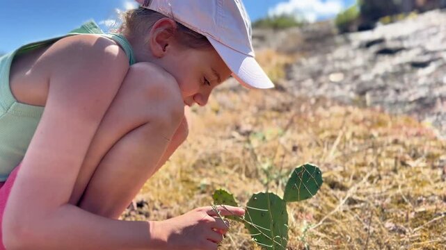 Young Girl Crouching Near Small Cactus Outdoor Horizontal Shot