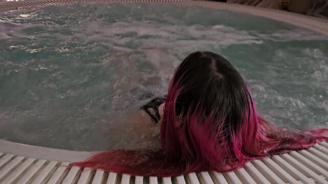 Relaxing in hot tub at home during evening hours with water splashing softly