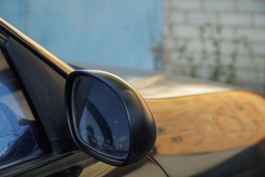 Close up of car wing mirror with safety warning text horizontal