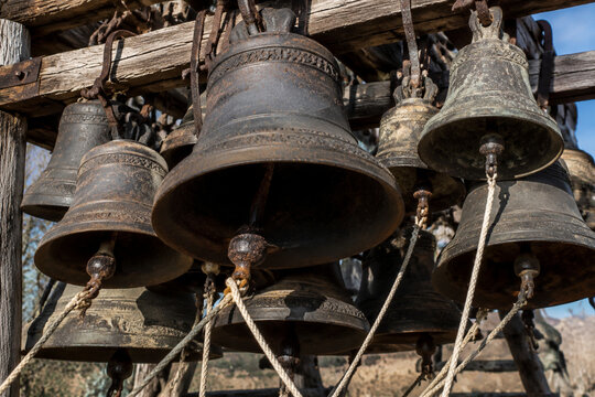 Old cast-iron bells cluster on wooden frame, sound and tradition concept