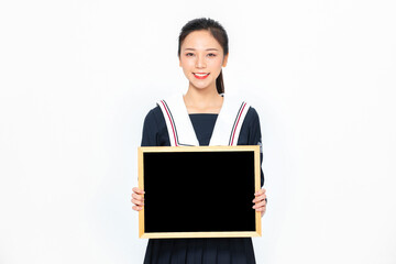 Smiling Asian student in school uniform holding blank blackboard © CungTuan