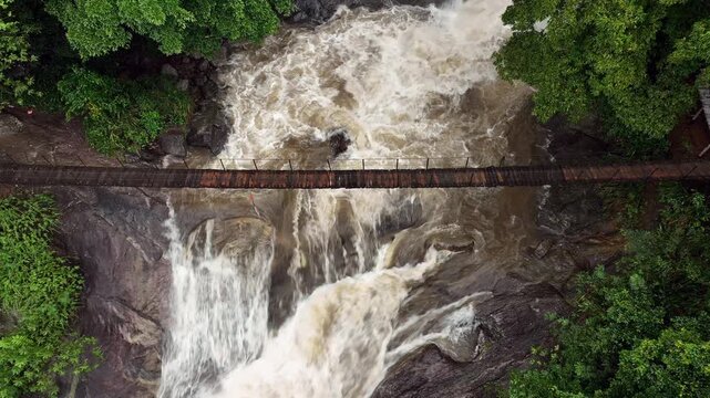 Drone aerial of Bambarakiri Ella Falls near Wadakahamada, Sri Lanka, featuring a beautiful tropical waterfall surrounded by lush forest and rocky cliffs.