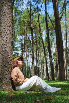 Vertical portrait image of a woman sitting and relaxing in the park