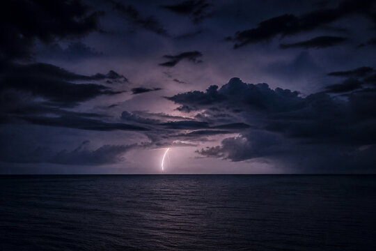 Distant lightning above a dark open ocean