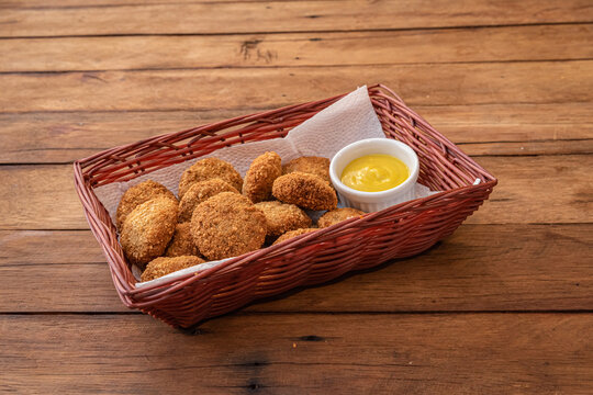 Brazilian disco de carne - Beef nuggets nuggets in basket with mustard sauce