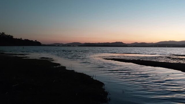 Windy Ibiraquera lagoon and outlet channel at dusk
