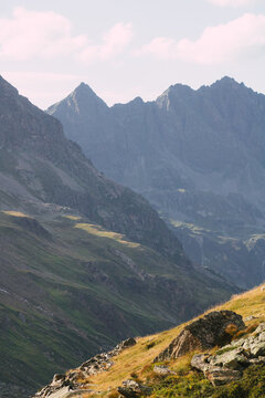 Dramatische alpine Hochgebirgslandschaft mit schroffen Gipfeln und sonnigem Berghang