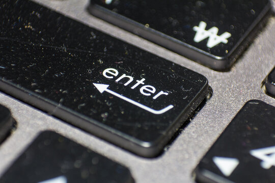 Close up of an enter key on a black computer keyboard for data input and confirmation