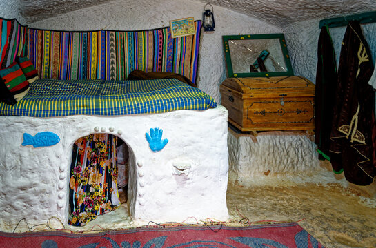 Interior View of Traditional Troglodyte Bedroom with Textured White Cave Walls and Folk Decor