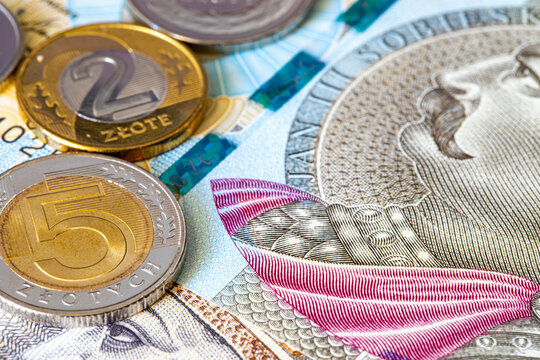 Polish zloty coins rest on top of 200 and 500 zloty banknotes. Polish national currency PLN. European finance.