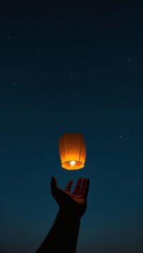 Generative AI depicts an orange sky lantern being released into a starry night sky
