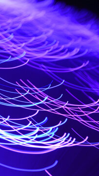 Vertical abstract background with neon blue and purple light trails for smartphone wallpaper
