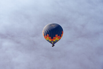 Colorful hot air balloon floating alone in a misty sky © William
