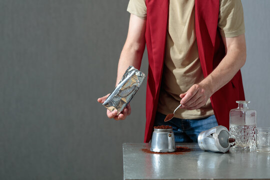 A barista prepares a coffee using a classic Italian moka pot.