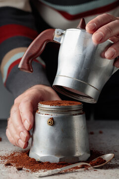 Man is prepared coffee in a classic Italian aluminium moka pot.