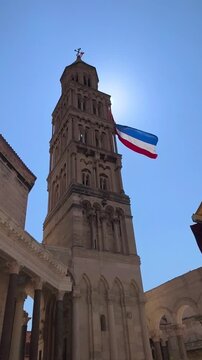 Supetar, Croatia - August 04, 2026: Bell tower of Saint Domnius Cathedral in Split, Croatia, decorated with the Croatian flag. Bell tower with French flag waving under bright sun in historical