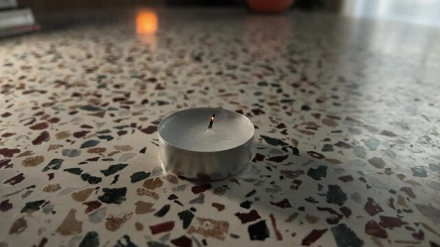Thin smoke rising from a freshly extinguished tealight candle wick