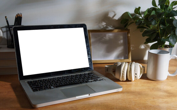 Blank laptop screen displayed on a styled modern workspace desk.