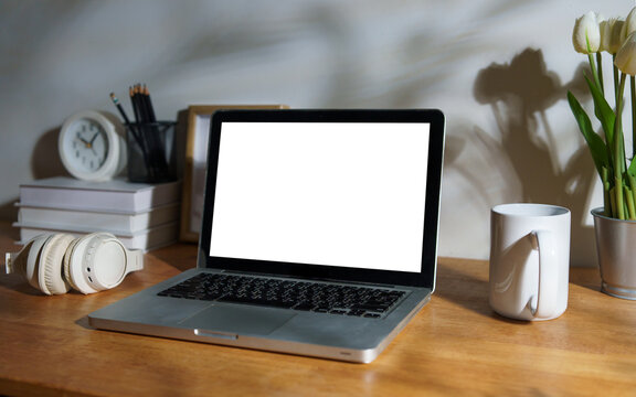 Blank laptop screen displayed on a styled modern workspace desk.