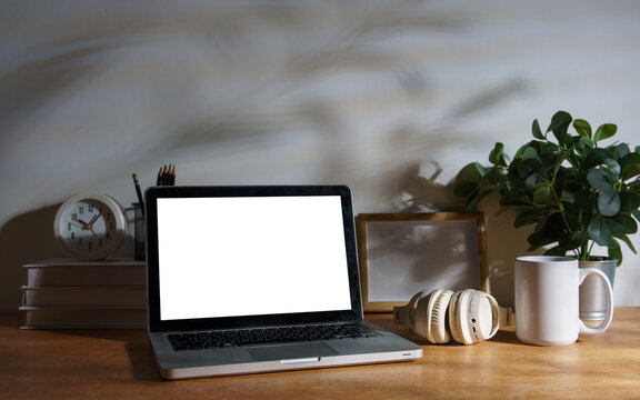 Blank laptop screen displayed on a styled modern workspace desk.